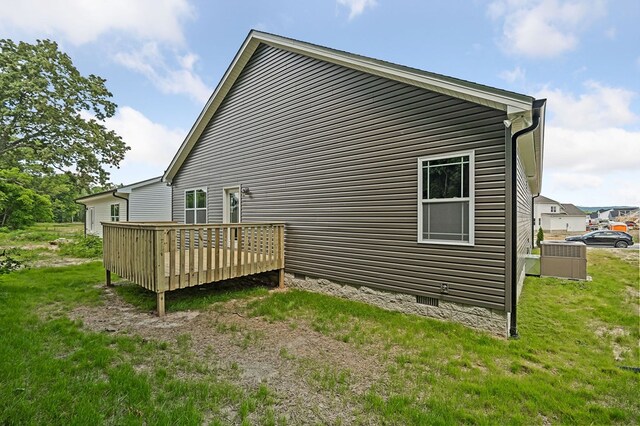 view of side of home with a deck and a yard