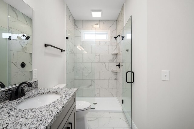 full bathroom with marble finish floor, toilet, a stall shower, vanity, and baseboards