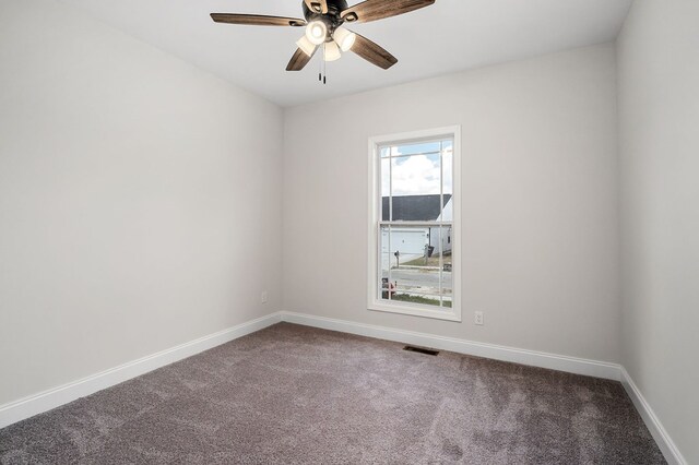 carpeted spare room with a ceiling fan, visible vents, and baseboards