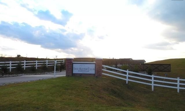 exterior space featuring a rural view, fence, and a lawn