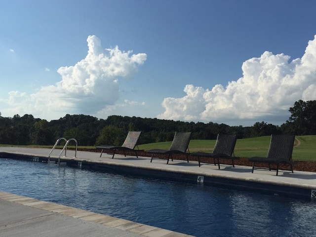 view of pool featuring a water view