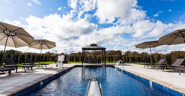 view of swimming pool with a gazebo, a patio, fence, and a fenced in pool