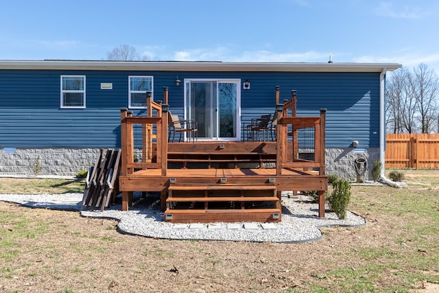 rear view of property featuring a deck and fence