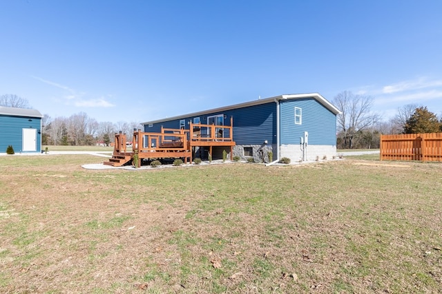 back of house featuring a wooden deck, a yard, and fence