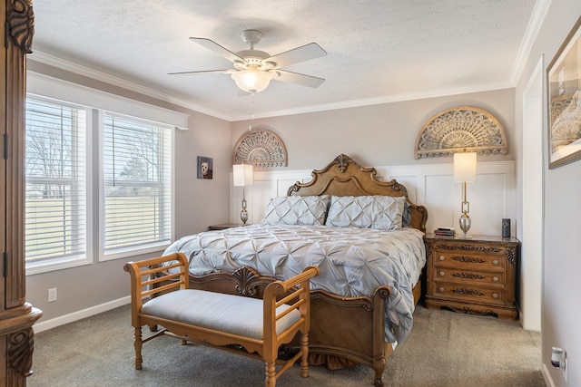 carpeted bedroom with a textured ceiling, a ceiling fan, baseboards, and ornamental molding