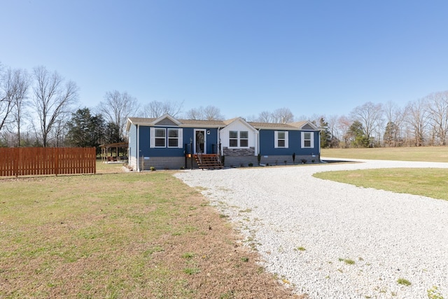 view of front facade featuring crawl space, gravel driveway, a front yard, and fence