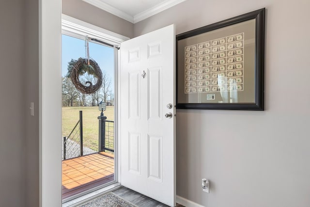 foyer featuring crown molding, plenty of natural light, and wood finished floors