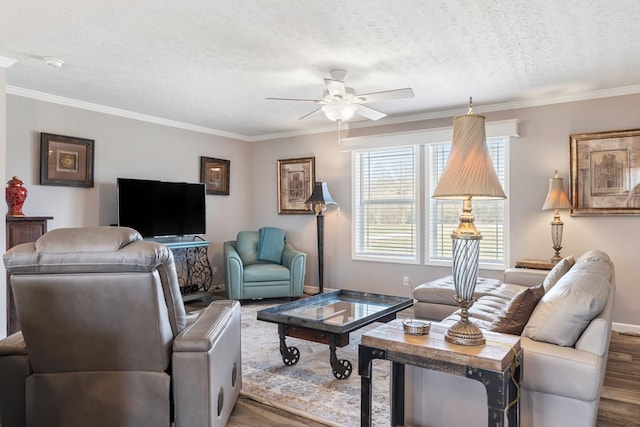 living room featuring wood finished floors, a ceiling fan, baseboards, a textured ceiling, and crown molding