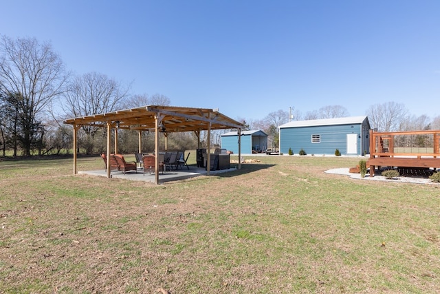 view of yard featuring an outbuilding, a patio area, and a wooden deck