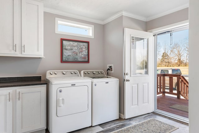 washroom with crown molding, cabinet space, light wood-style floors, and washer and clothes dryer