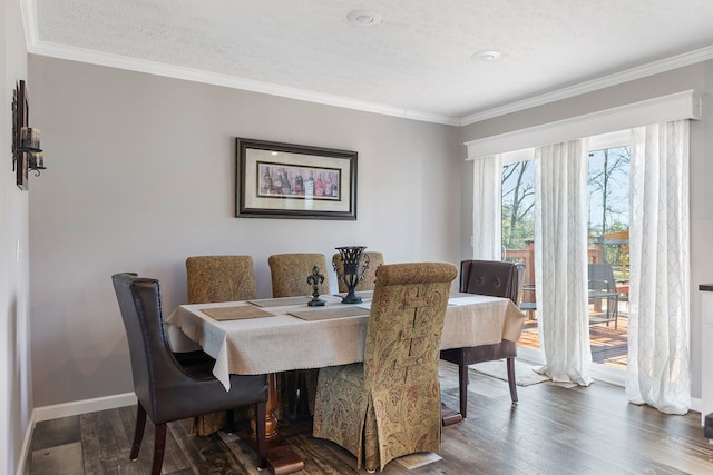 dining space featuring baseboards, a textured ceiling, wood finished floors, and crown molding