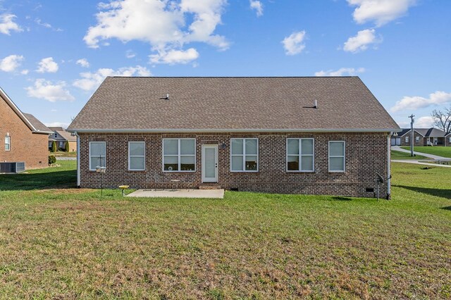 back of property with central AC unit, roof with shingles, a yard, a patio area, and brick siding