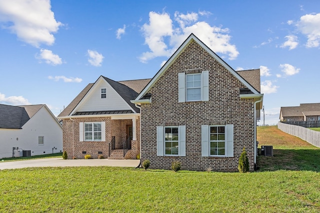 traditional-style home featuring cooling unit, a front lawn, a patio, and brick siding