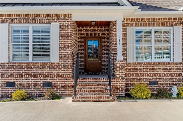 doorway to property with roof with shingles, brick siding, and crawl space