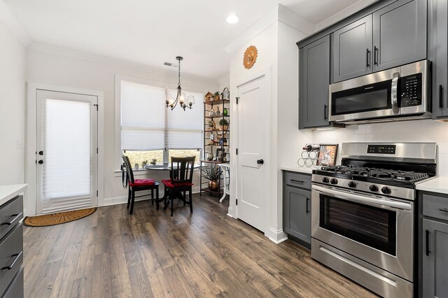 kitchen with stainless steel appliances, gray cabinets, light countertops, and decorative light fixtures