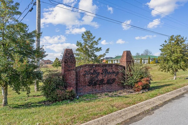 community / neighborhood sign featuring a yard