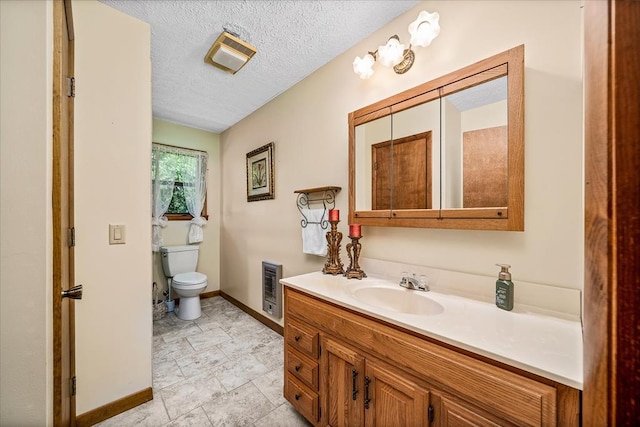 bathroom featuring baseboards, toilet, heating unit, a textured ceiling, and vanity