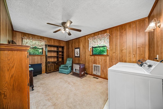 interior space with light carpet, ceiling fan, heating unit, a textured ceiling, and washer and dryer