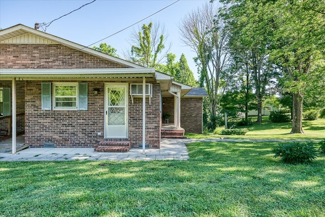 exterior space with a patio area, a front lawn, and brick siding