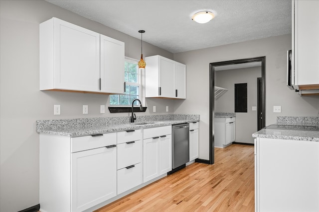 kitchen with a sink, white cabinetry, hanging light fixtures, light wood-type flooring, and dishwasher