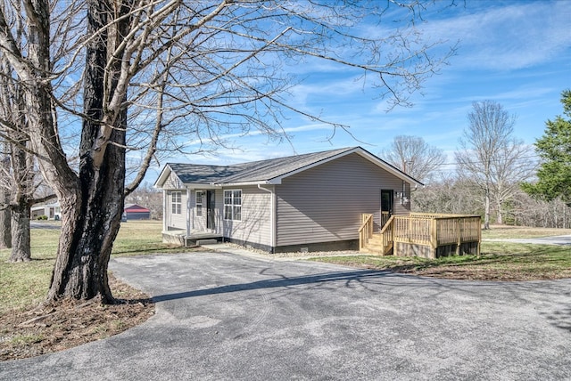 view of property exterior featuring aphalt driveway, crawl space, and a deck