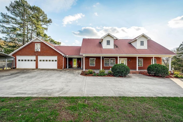 view of front facade featuring driveway, an attached garage, metal roof, and brick siding