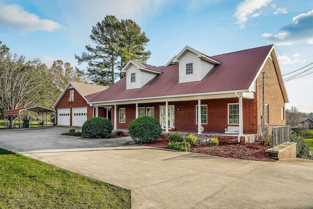 view of front facade with covered porch, brick siding, metal roof, and driveway