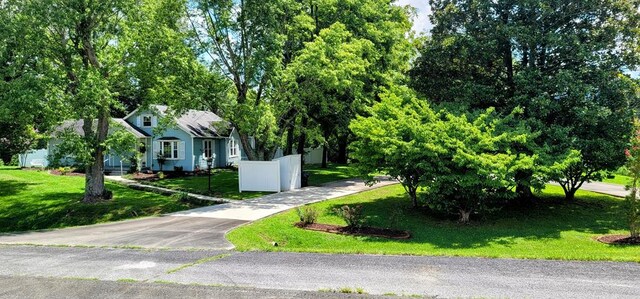 view of front of property featuring concrete driveway, a front yard, and fence