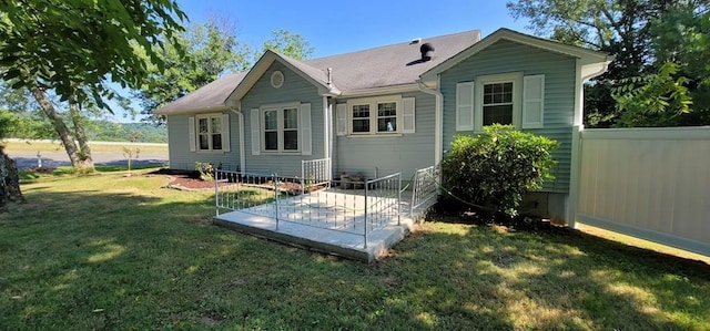 rear view of house with a patio area, a lawn, and fence