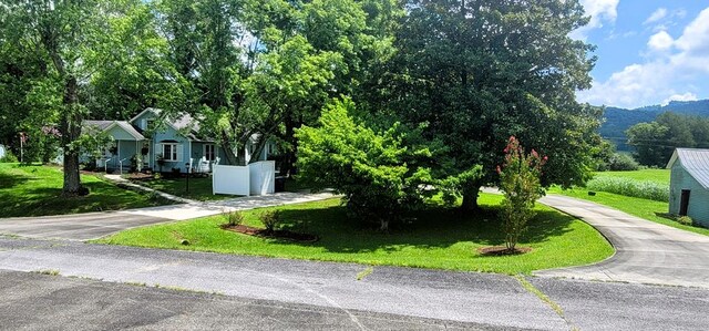 exterior space with fence, a front lawn, and concrete driveway