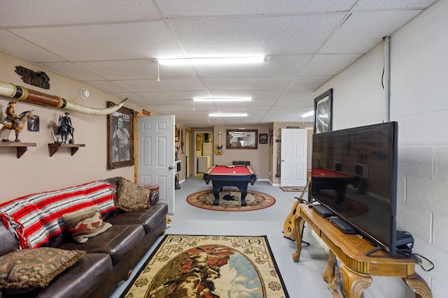 living room featuring concrete flooring, concrete block wall, a drop ceiling, and billiards