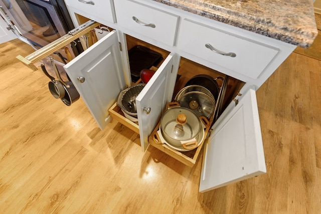 interior details featuring white cabinetry and light wood-style flooring