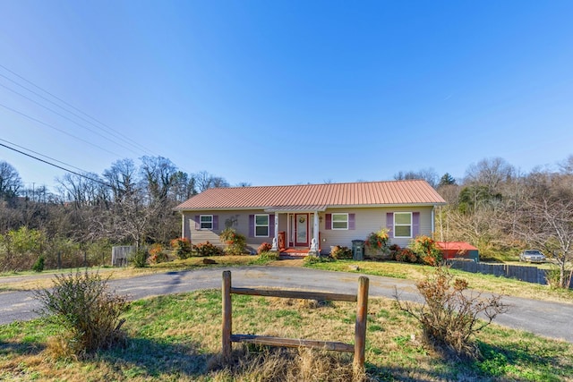 single story home featuring fence and metal roof