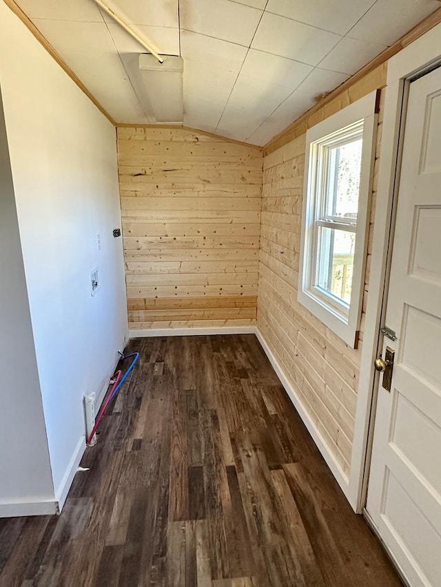 unfurnished room featuring wooden walls, baseboards, dark wood-type flooring, and lofted ceiling