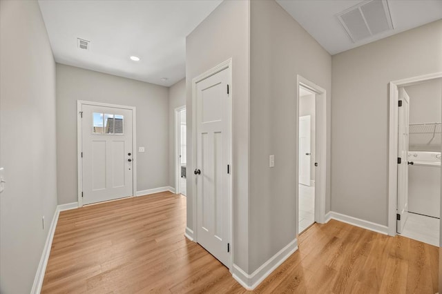 foyer entrance with light wood-style floors, baseboards, and visible vents