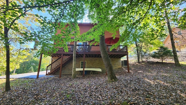 back of property with a wooden deck and stairs