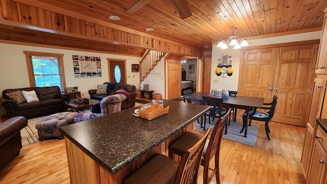 kitchen featuring a kitchen bar, light wood-style floors, open floor plan, and wooden ceiling