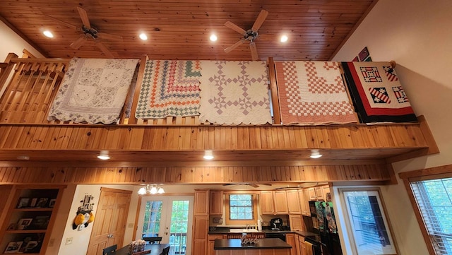 kitchen with dark countertops, wooden ceiling, a high ceiling, and ceiling fan