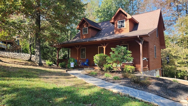 rustic home with a front yard, a garage, and covered porch