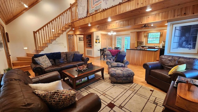 living room with visible vents, high vaulted ceiling, light wood-style flooring, stairway, and wood ceiling