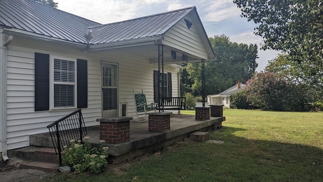 exterior space with metal roof and a lawn