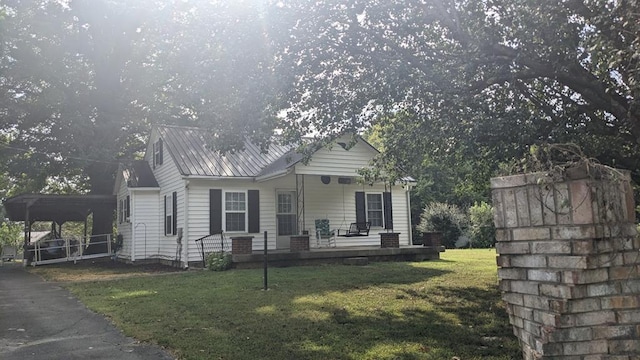 view of front of home featuring a front yard, covered porch, and metal roof