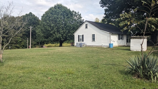 view of home's exterior with a yard, a shed, and an outdoor structure