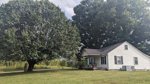 view of property exterior featuring a porch, metal roof, and a yard