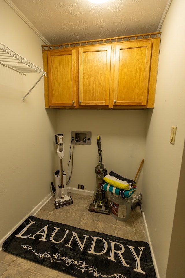 laundry area featuring washer hookup, cabinet space, a textured ceiling, baseboards, and tile patterned floors