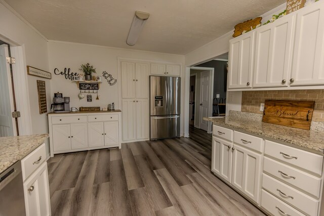 kitchen with stainless steel appliances, white cabinetry, light stone counters, and open shelves