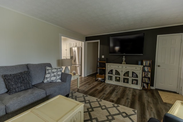 living room with dark wood-style floors, ornamental molding, and a textured ceiling