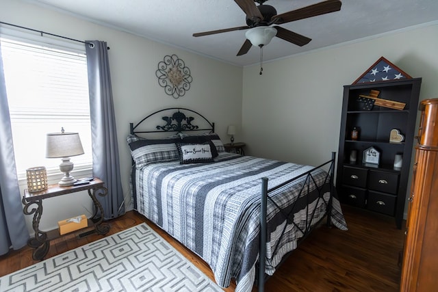 bedroom with ornamental molding and dark wood finished floors