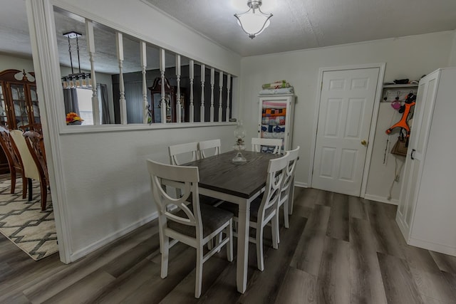 dining space with dark wood-style flooring, a textured ceiling, and baseboards