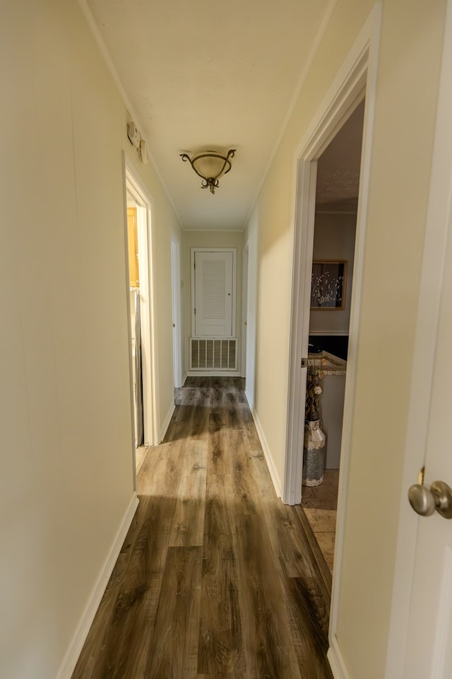 corridor featuring visible vents, crown molding, baseboards, and wood finished floors